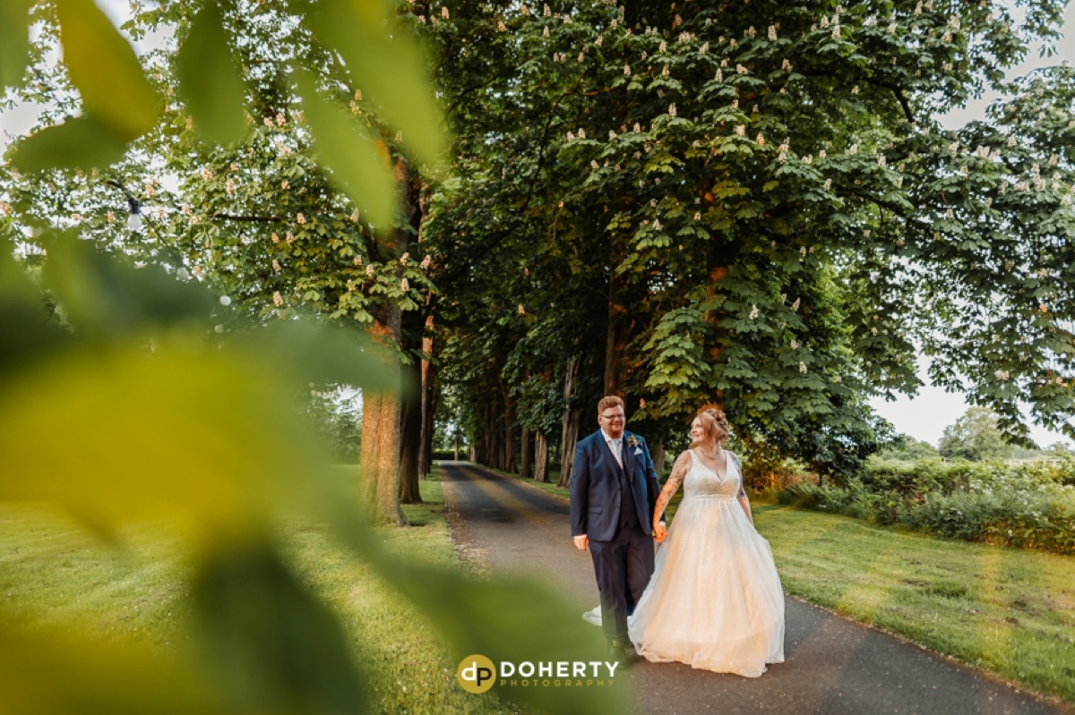 bride and groom walking in gardens at Hogaths - Solihull