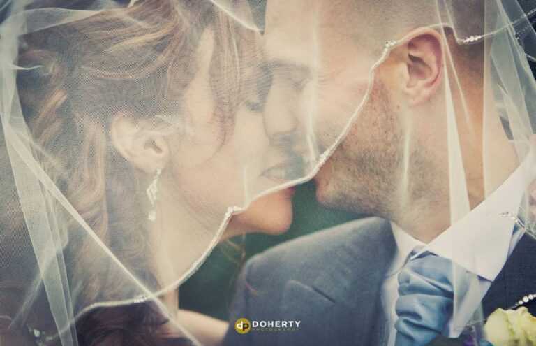 Close up of bride and groom under a veil at Bourton Hall